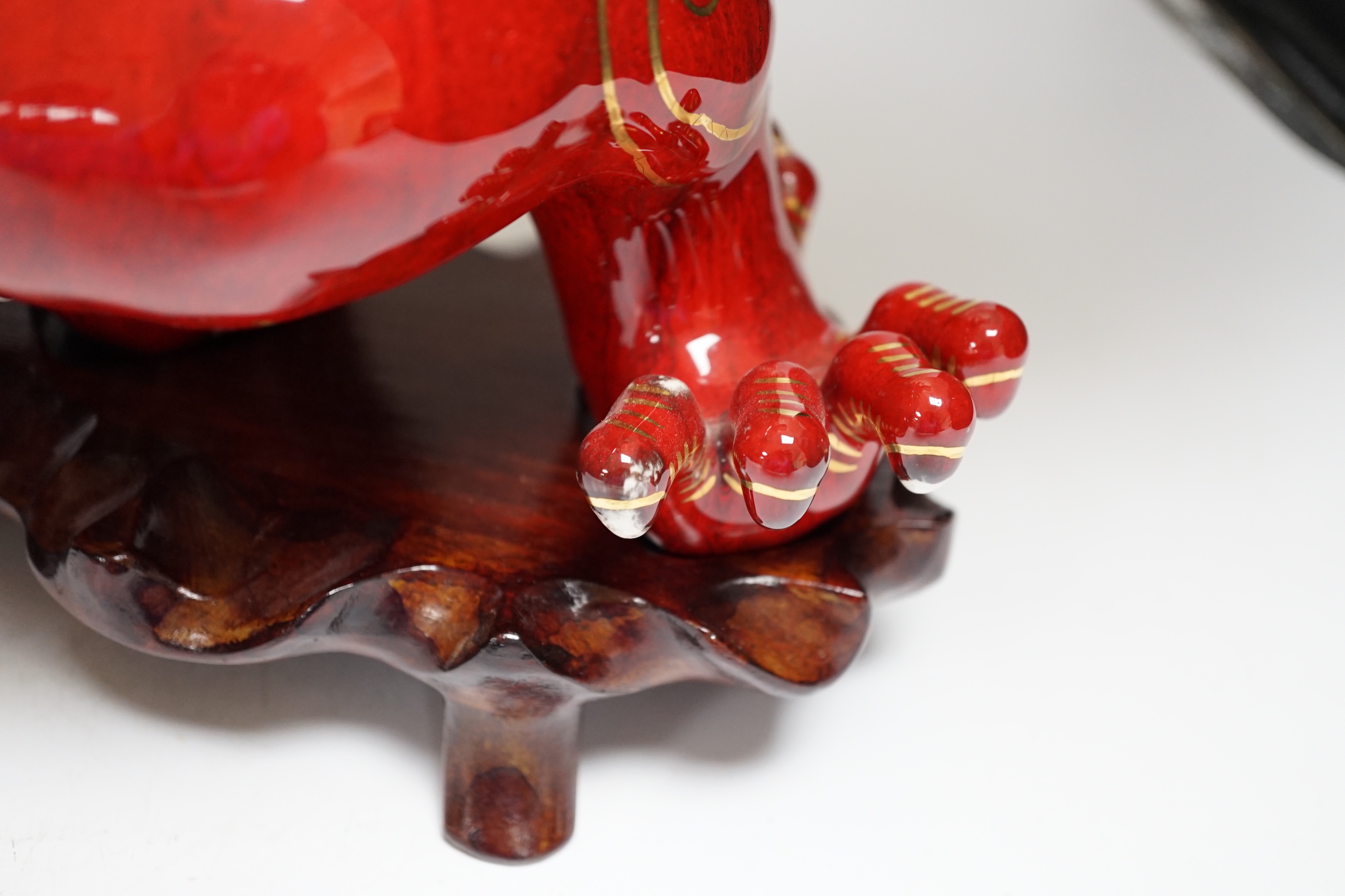 A modern Chinese red and gilt glazed ceramic 'dragon' table lamp on carved wood stand with shade, total height 68cm